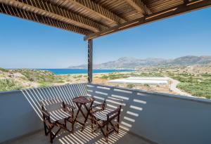 a balcony with two chairs and a table on it at Athena Villas in Makry Gialos