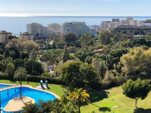 - une vue sur un parc avec une piscine et une ville dans l'établissement MiNERVA, à Benalmádena