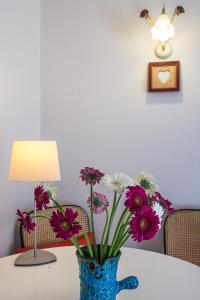 a blue vase filled with flowers on a table at Studio des Musiciens - quartier Orangerie in Strasbourg