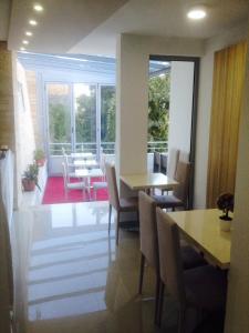 a dining room with tables and chairs and a large window at Apartments Croma in Ulcinj