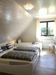 1 dormitorio con 2 camas y ventana en Appartements Friedrichsen en List