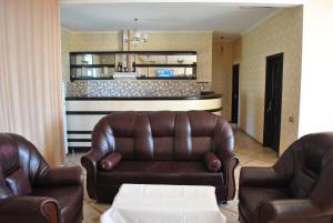 a living room with two leather chairs and a couch at Seki Qonaq Evi in Sheki