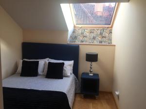 Dormitorio pequeño con cama y ventana en Apartamento Conde Luna, en León