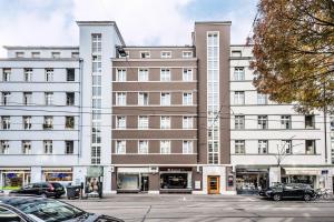 un gran edificio con coches estacionados en un estacionamiento en Boutique Hotel NI-MO en Zúrich