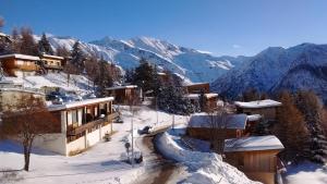 einen schneebedeckten Berg mit Gebäuden und eine Straße mit Schnee in der Unterkunft Le Plein Soleil 2 510 in Orcières