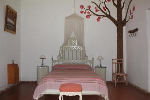 a bedroom with a bed with a tree on the wall at La Casa de Wanda in Villa de Las Rosas +30 photos