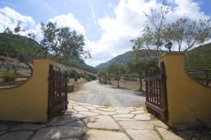 a dirt road leading to a stone wall at Agriturismo Sa Rocca in Iglesias
