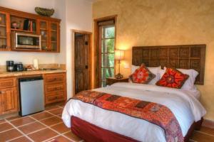 a bedroom with a large bed and a kitchen at Villa Thornhill in Palm Springs