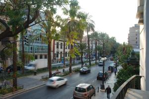 una concurrida calle de la ciudad con coches y gente en la acera en Reino de Valencia Apartments, en Valencia