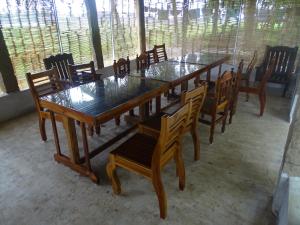 a dining room with wooden tables and wooden chairs at Paddy Homestay in Thanjāvūr