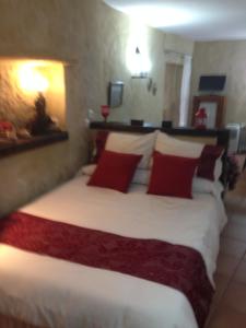 a bedroom with a large bed with red pillows at Casas Andrea La Cueva in Vejer de la Frontera