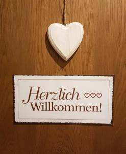 um sinal com um coração pendurado numa parede em Apartment Bergverliebt em Mieming