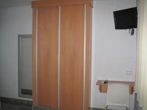 een houten kast in een kamer met een televisie bij Hostal Ducal II in Gandía