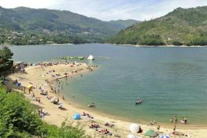 un grupo de personas en una playa en el agua en Casa Feijao - Alojamento Local, en Gerês