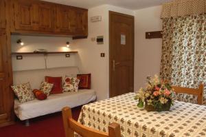 Un dormitorio con una cama y una mesa con flores. en Residence Pavou, en Cogne