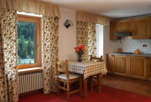 a kitchen with a table with a vase of flowers on it at Residence Pavou in Cogne