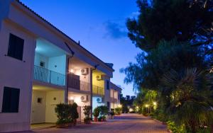 a cobblestone street with buildings and palm trees at night at Residence Chiesiola in Vieste