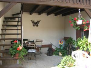 una mariposa en la pared de un patio con mesa y sillas en Martinas-Gästehaus, en Hornbach