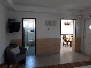 - un salon avec une chaise et une porte en verre dans l'établissement Apartments Rinčić, à Marina
