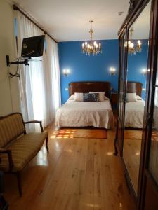 1 dormitorio con cama, sofá y espejo en Casa España, en Villaviciosa