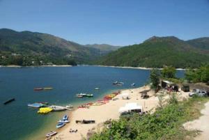 un grupo de barcos en una playa en el agua en Casa Feijao - Alojamento Local, en Gerês