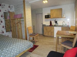 a room with a kitchen and a bed and a table at Ferienapartments am Dorfplatz in Langscheid +3 photos