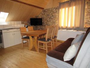 a kitchen and dining room with a wooden table and chairs at Ferienapartments am Dorfplatz in Langscheid