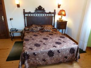 1 dormitorio con 1 cama y 1 lámpara en una mesa en Casa España, en Villaviciosa