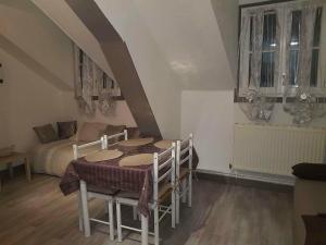 a dining room with a table and a bed at Résidence du Baliran in Luchon