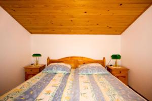 1 dormitorio con 1 cama con 2 mesitas de noche en Zeleni apartma Zreče, en Zreče