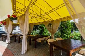 een patio met tafels en stoelen en een gele luifel bij Отель "Соборный" in Bila Tserkva