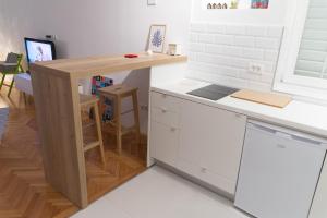 a small kitchen with a counter and a table at Bright & Stylish Studio Home, superbly located in Sarajevo