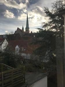 Blick auf eine Stadt mit einer Kirche mit einem Uhrturm in der Unterkunft Glover Suite in Lübeck