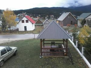 a house with a gazebo on a yard with a car at Guesthouse Mijatovic in Žabljak