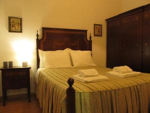 a bedroom with a bed with two towels on it at Casa da Ribeira in Santarém