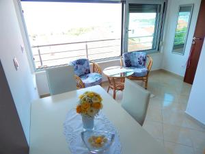 ein weißer Tisch mit einer Vase Blumen drauf in der Unterkunft Apartments Linda in Trogir