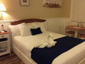 a white stuffed animal laying on a bed at The Beachwood in Old Orchard Beach