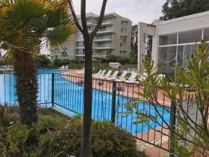 a swimming pool with lounge chairs next to a building at Condominio Alto Mar in Puchuncaví