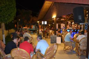 een groep mensen die 's nachts in een restaurant zitten bij Belcehan Beach in Oludeniz