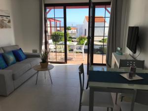 een woonkamer met een bank en een tafel bij Bungalow Silvia in Caleta De Fuste