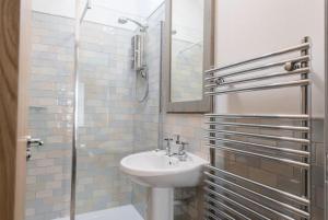 biała łazienka z umywalką i prysznicem w obiekcie The Toll House w mieście Newton Stewart