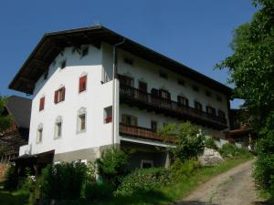 a white building with a balcony on a hill at Feldererhof in Siusi