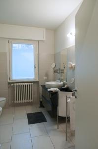 a bathroom with a sink and a toilet and a window at Relais Merizzi in Tirano