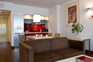 a living room with a couch and a kitchen at Mamaison Residence Diana in Warsaw