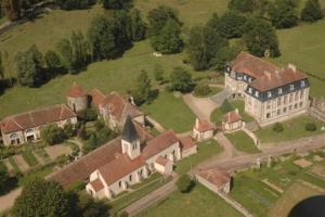 - une vue aérienne sur un grand domaine avec un bâtiment dans l'établissement Château de Flée, à Semur-en-Auxois