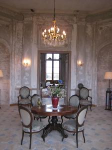 a dining room with a table and chairs and a chandelier at Château de Flée in Semur-en-Auxois