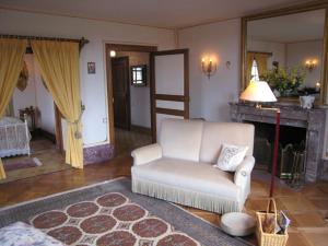 - un salon avec une chaise blanche et une cheminée dans l'établissement Château de Flée, à Semur-en-Auxois