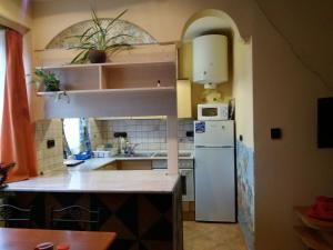 a kitchen with a white refrigerator and a sink at Kamilla Apartman in Esztergom