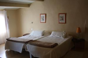 a bedroom with two beds and a window at La Cantarera in Herguijuela