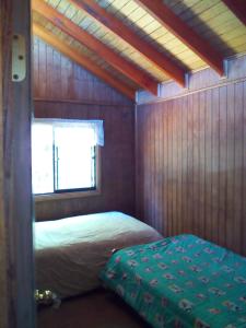 a small bedroom with a bed and a window at Los Encinos de Chancoyan in Valdivia +34 photos